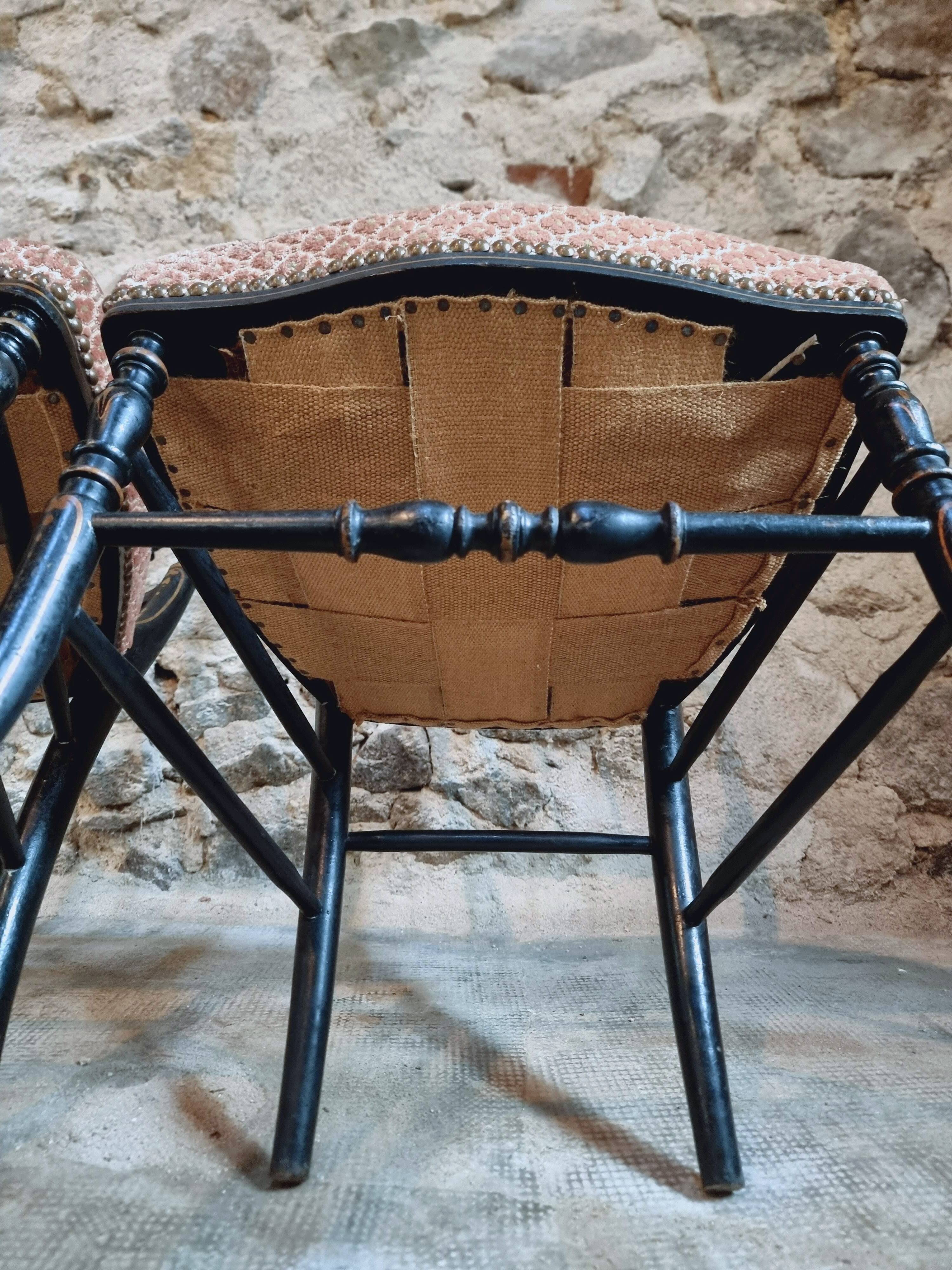 Pair of antique Napoleon III chairs in blackened wood and fabric.