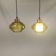 Hanging lamp with an outer shade of olive green glass and an inner shade of clear, crystal glass.