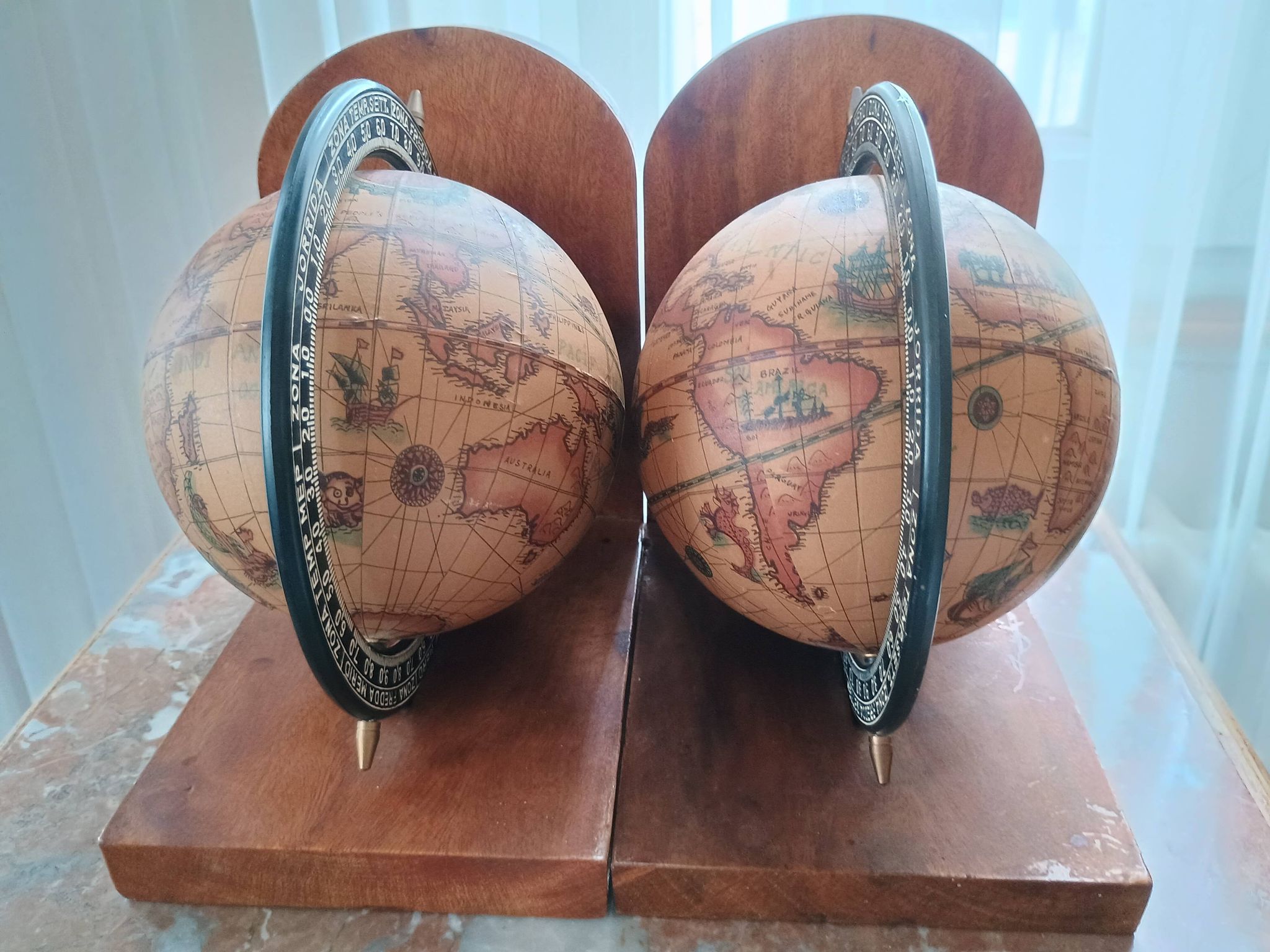 Pair of vintage bookends with rotating terrestrial globes on wooden bases in Spain