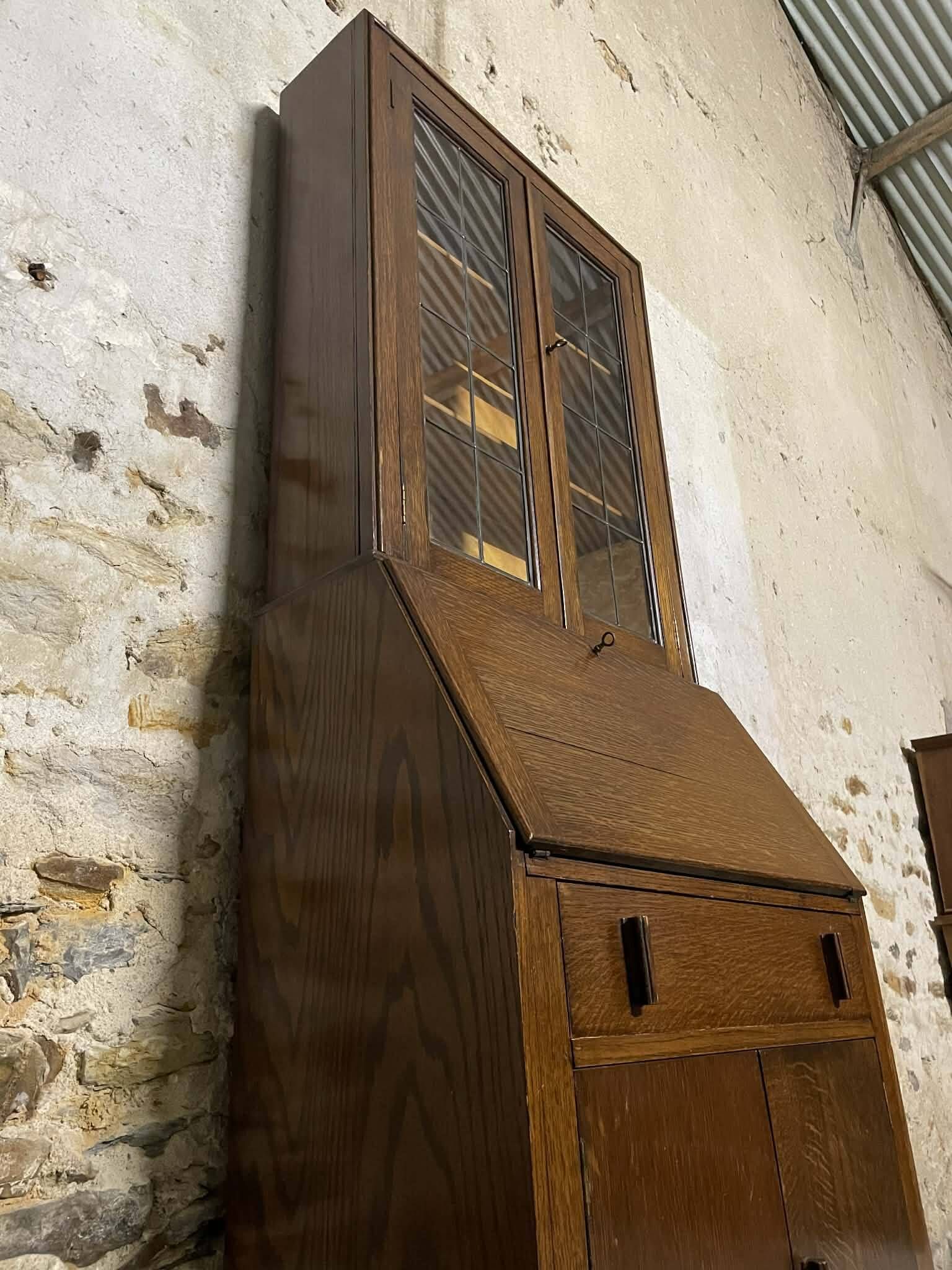 Oak display secretary cabinet with drop-down front, two sections.