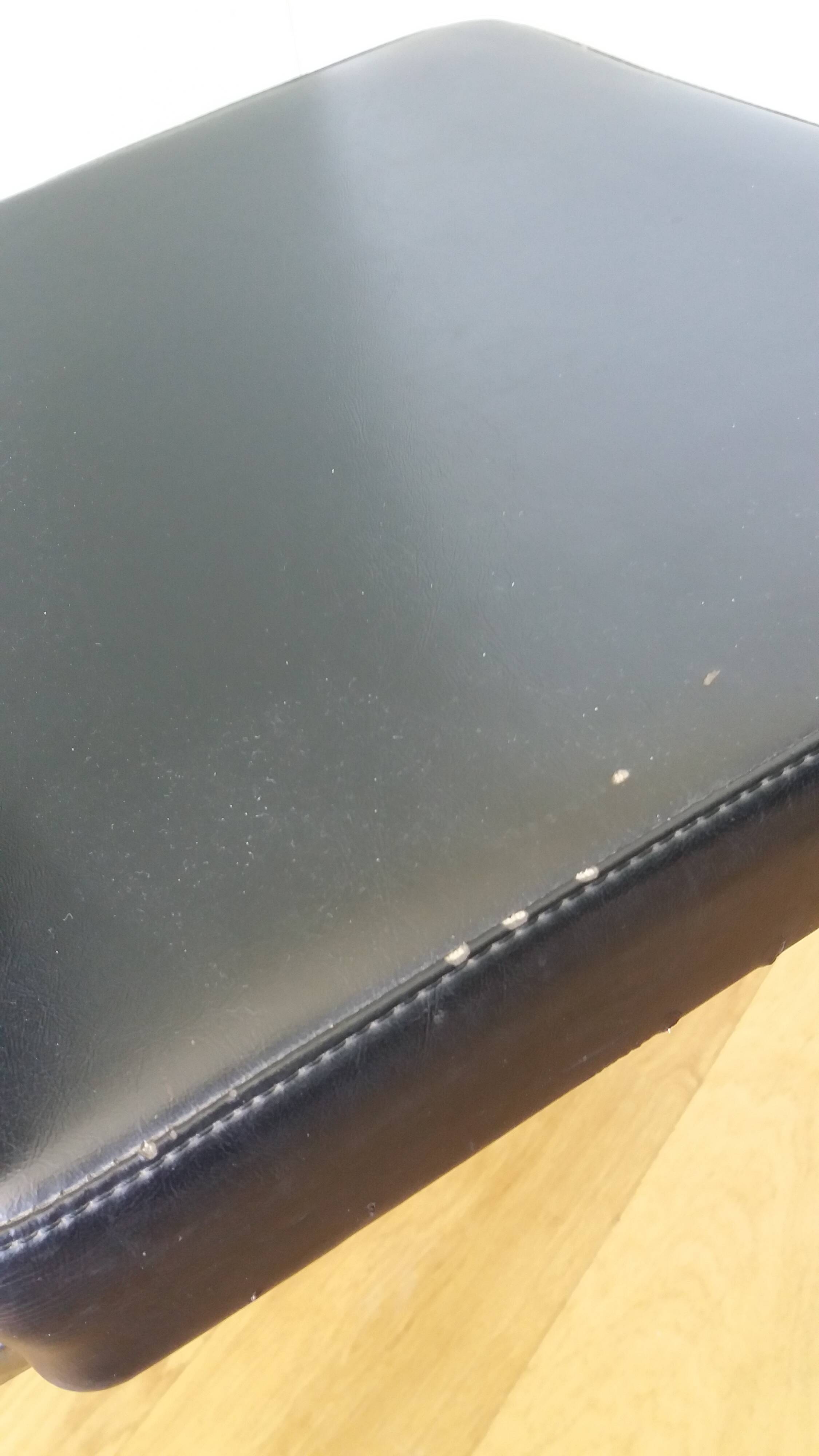 Chrome metal chairs and black faux leather upholstery in retro modernist style.