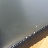 Chrome metal chairs and black faux leather upholstery in retro modernist style.