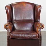 Dark English style sheepskin wingback chair with character and patina