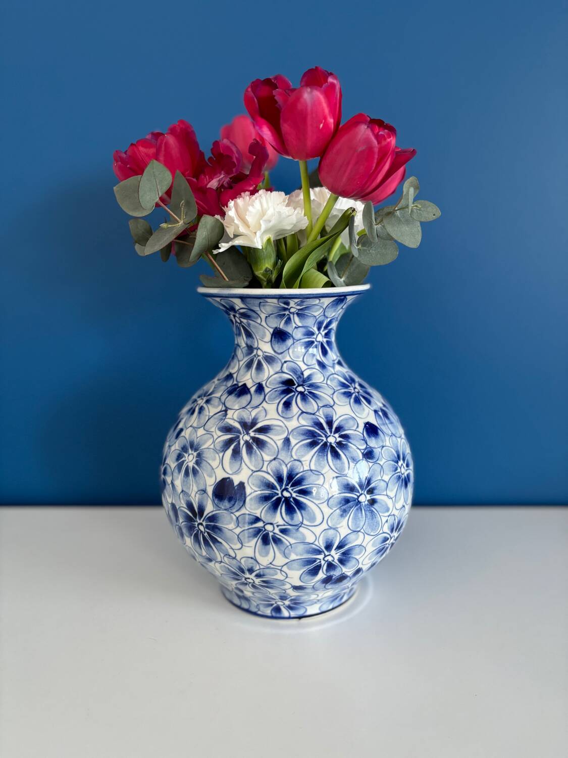 Blue and white ceramic vase with floral pattern in the shape of a vintage ball
