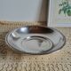 Shallow round metal plate with pearl bead decoration.