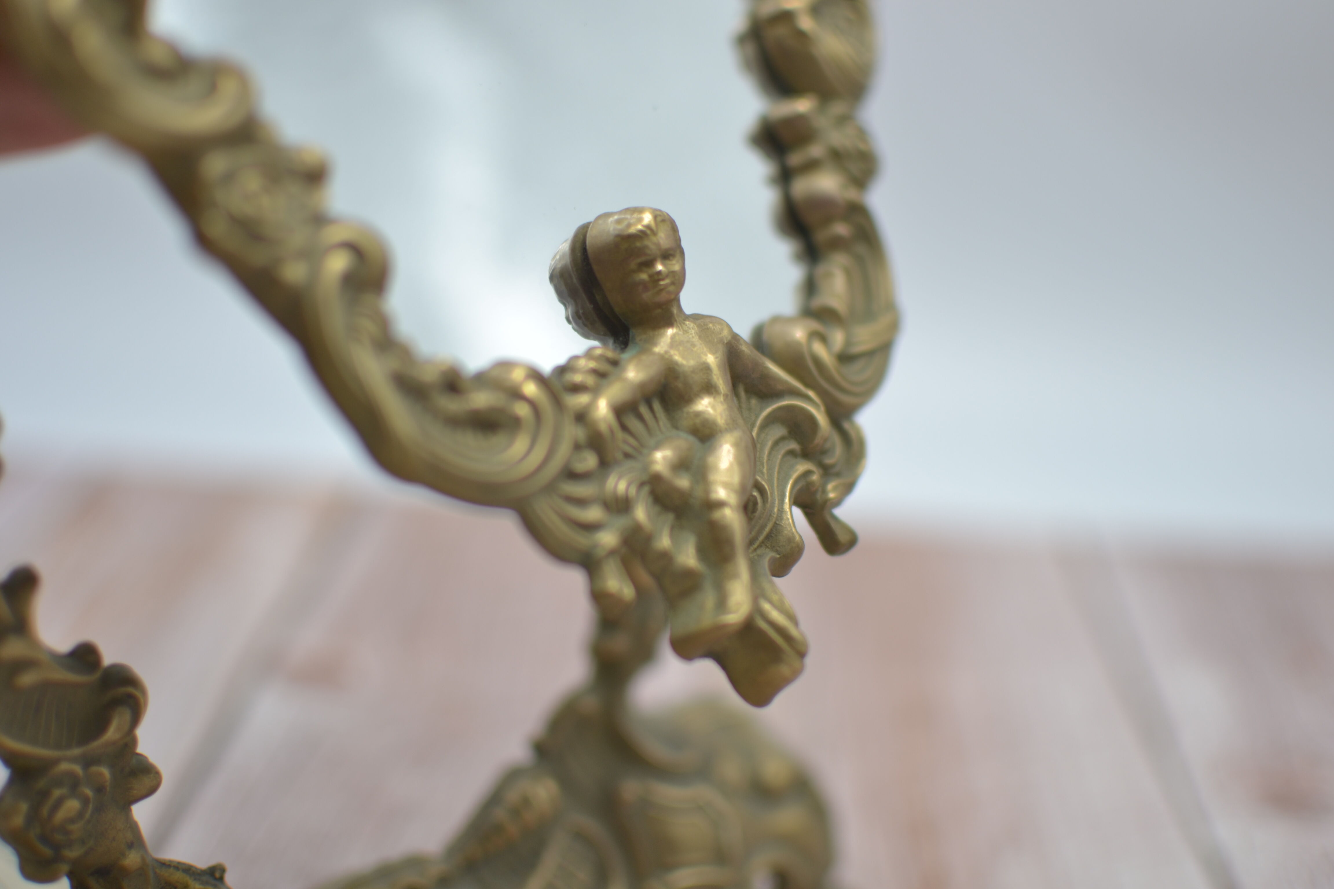 Adjustable psyche mirror of 33 centimeters in gilded bronze with angel ornament