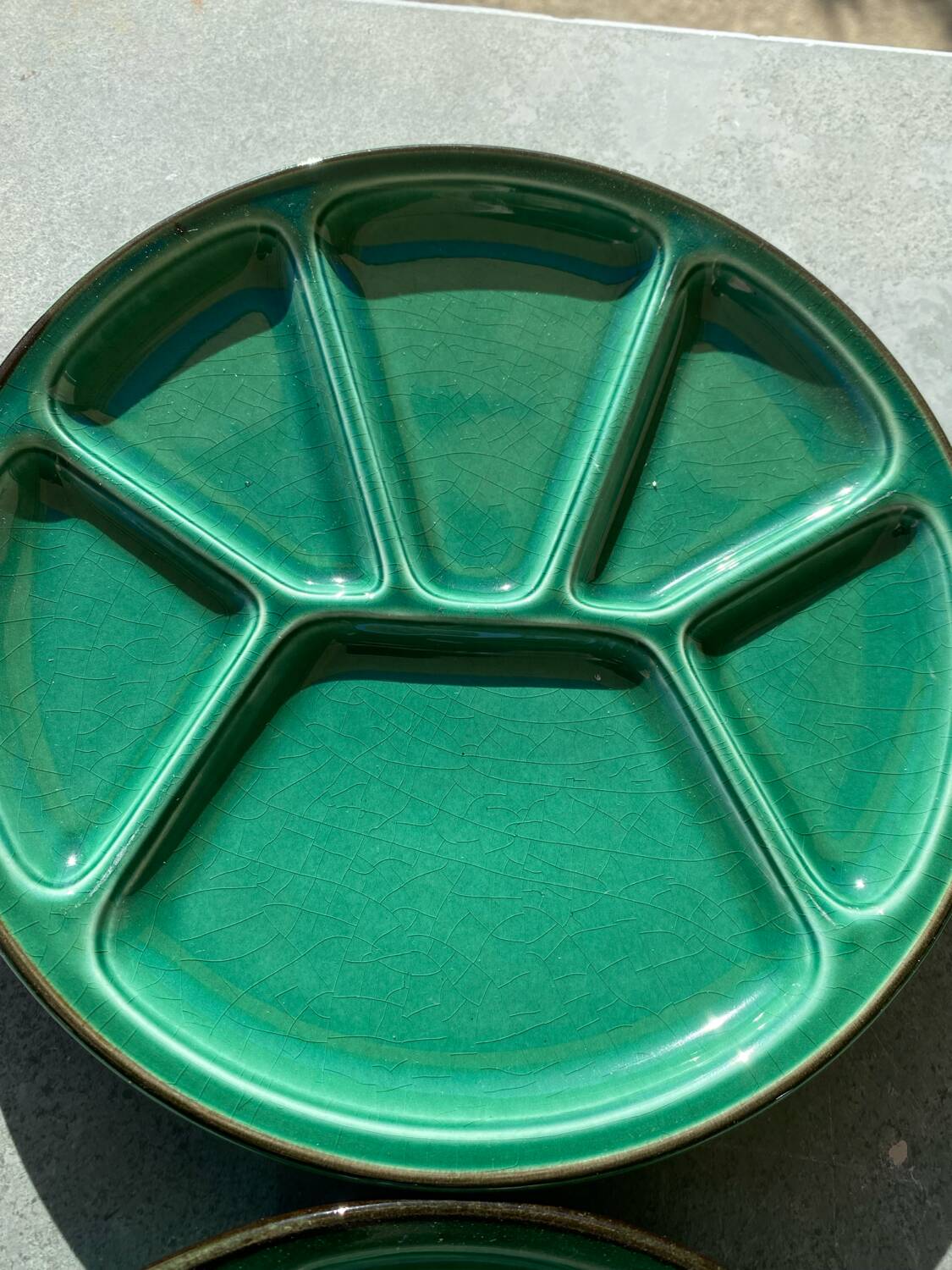 Many glazed stoneware plates with compartments.