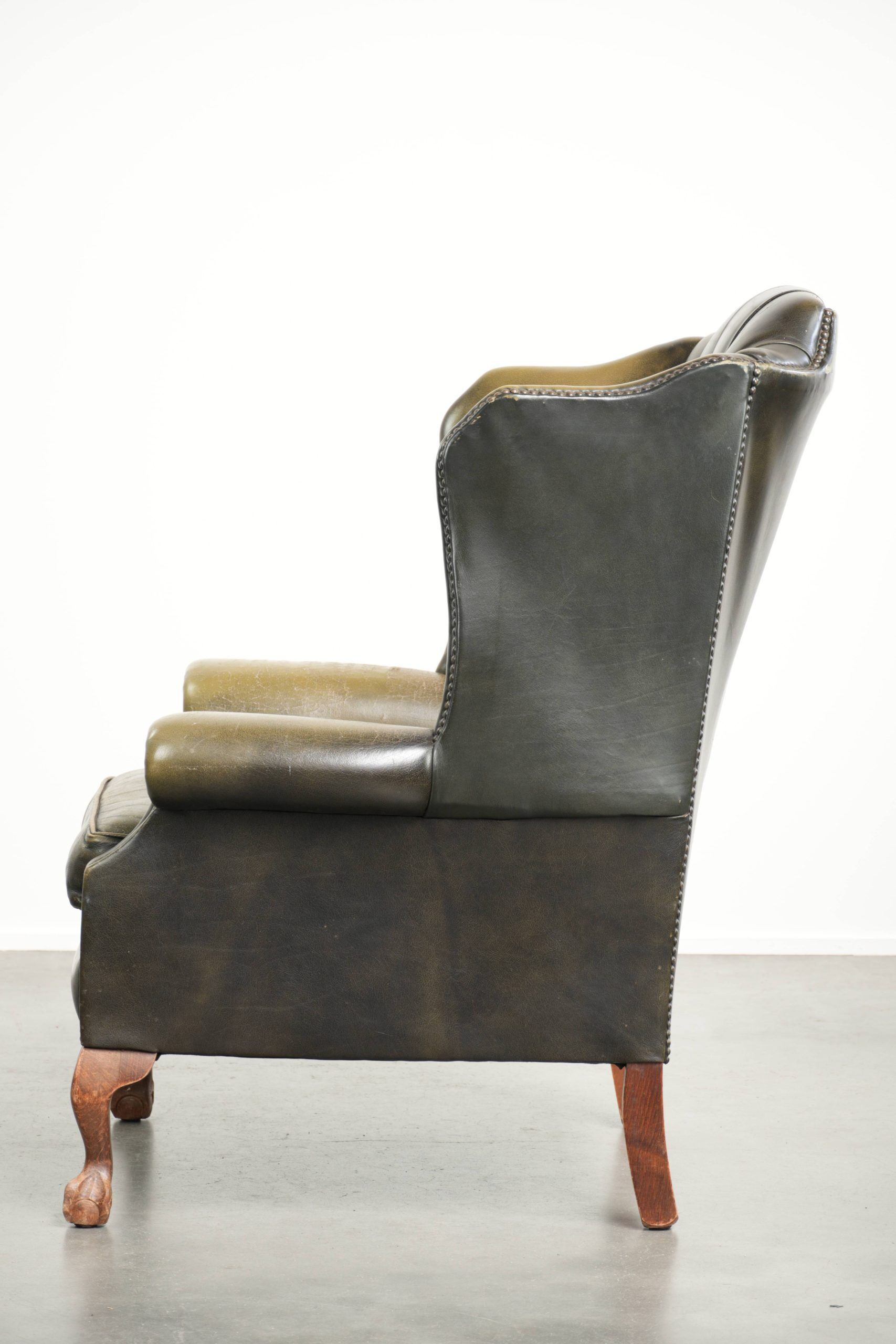Vintage cowhide leather Chesterfield wingback armchair in a green colour