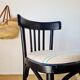 Curved black wooden bistro chair with striped seat