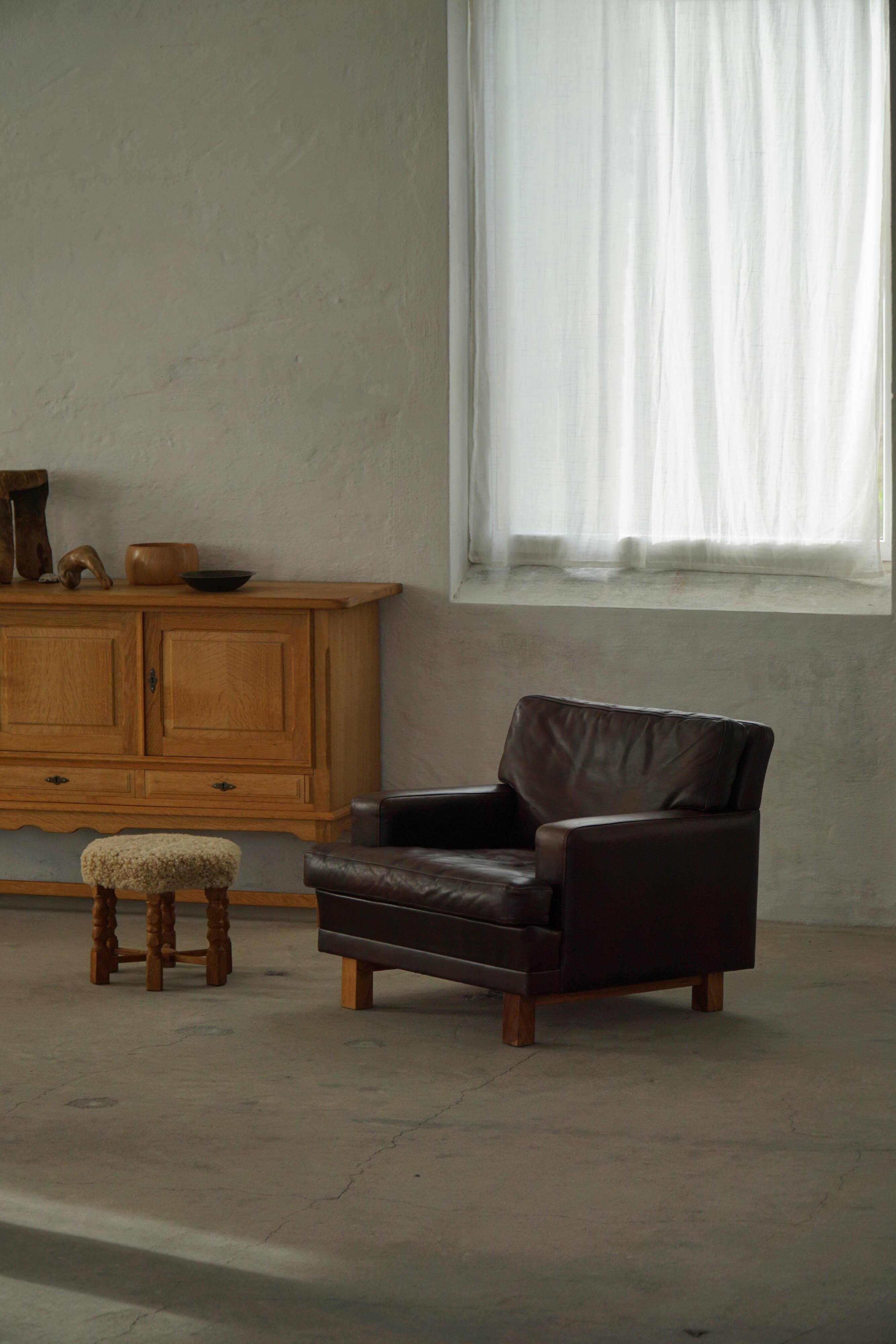 Pair of modern Danish lounge chairs in dark brown leather and rosewood, 1960s.