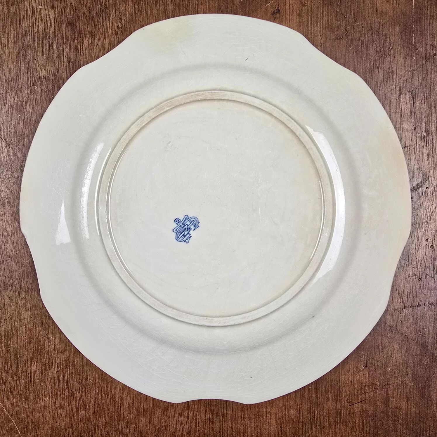 Old Gien plate with carved edges featuring doves and blue flowers, circa 1920-1930.