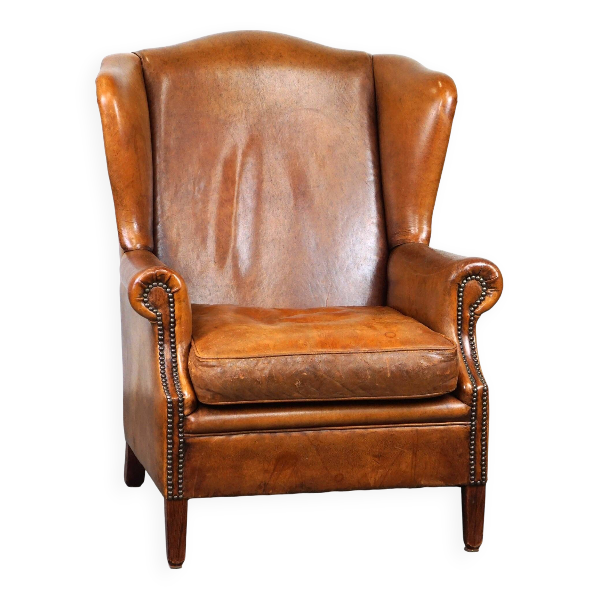Positively lived-in sheepskin leather wing chair with pleasant seating comfort