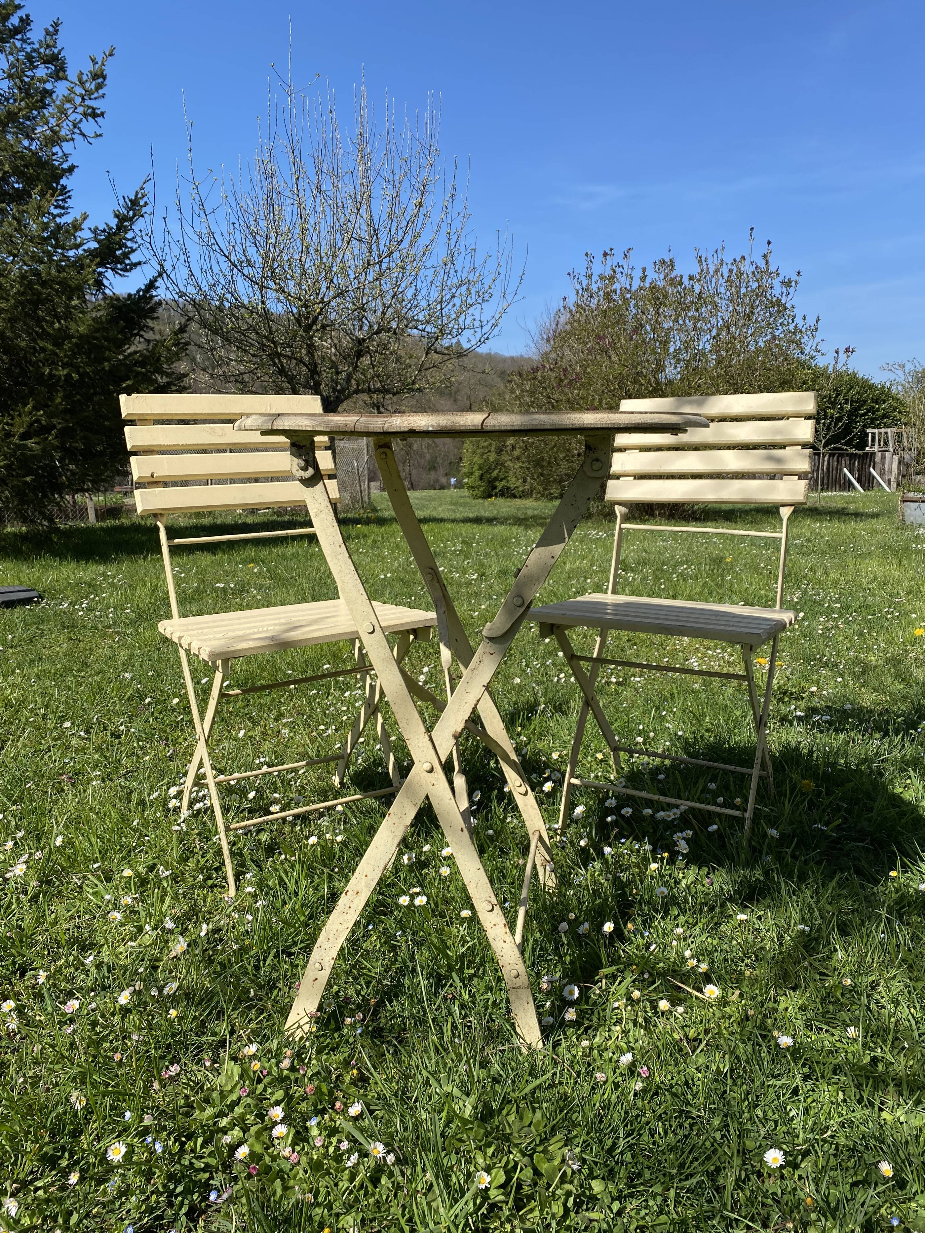 Table et 2 chaises de jardin en métal et bois beige marquées "Bistrot Paris"