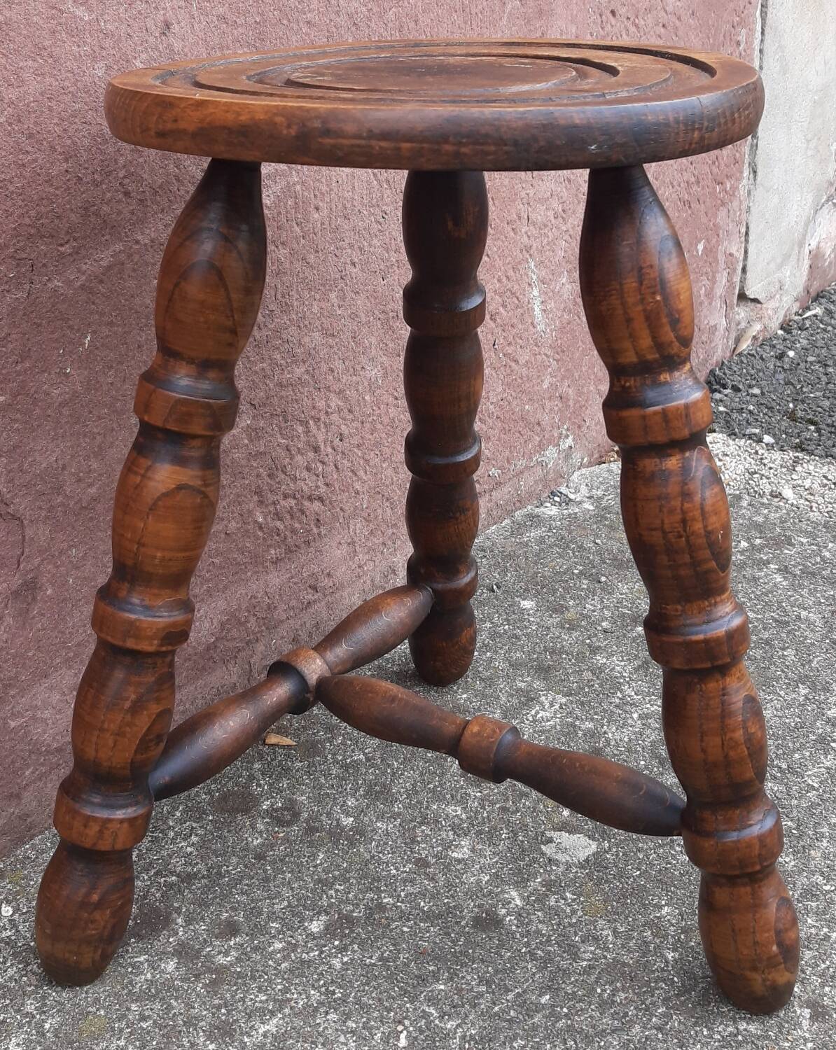 Low wooden tripod stool.