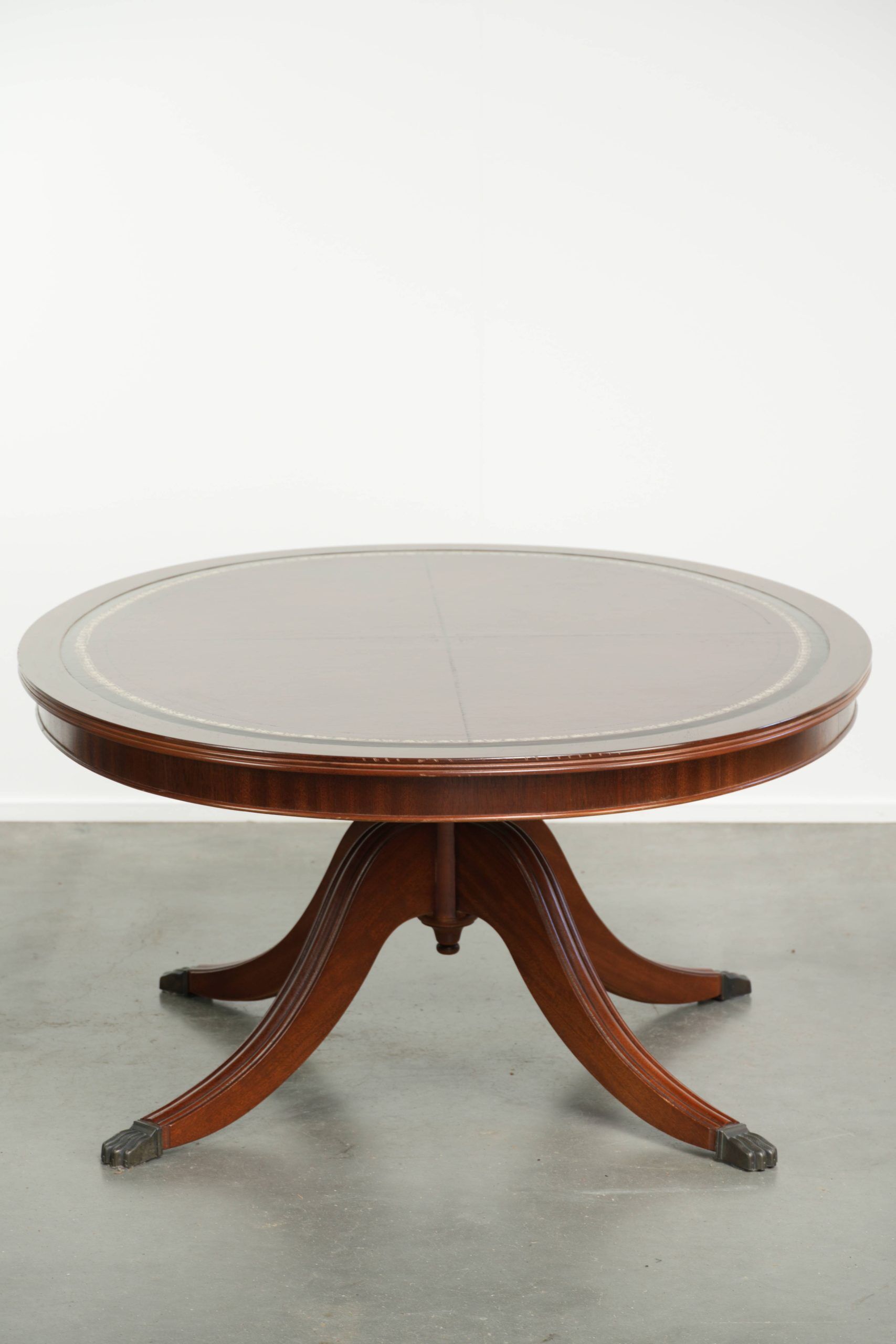 Table basse avec un plateau en cuir rouge de style anglais du 20e siècle.