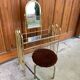 Hairdresser and vintage stool in gilded brass and mirror — brown seat, straw yellow accents.