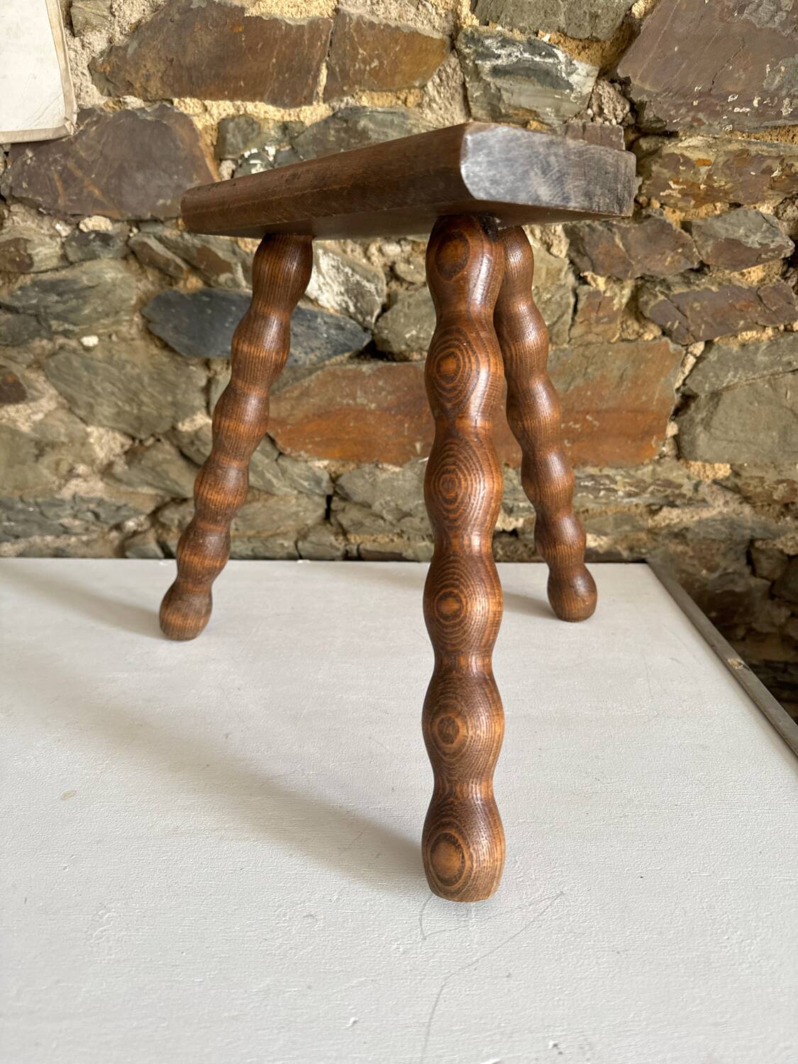 Low tripod stool with turned legs