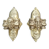 Pair of bronze wall sconces with mask, signed L. Pinet, Art Nouveau period.