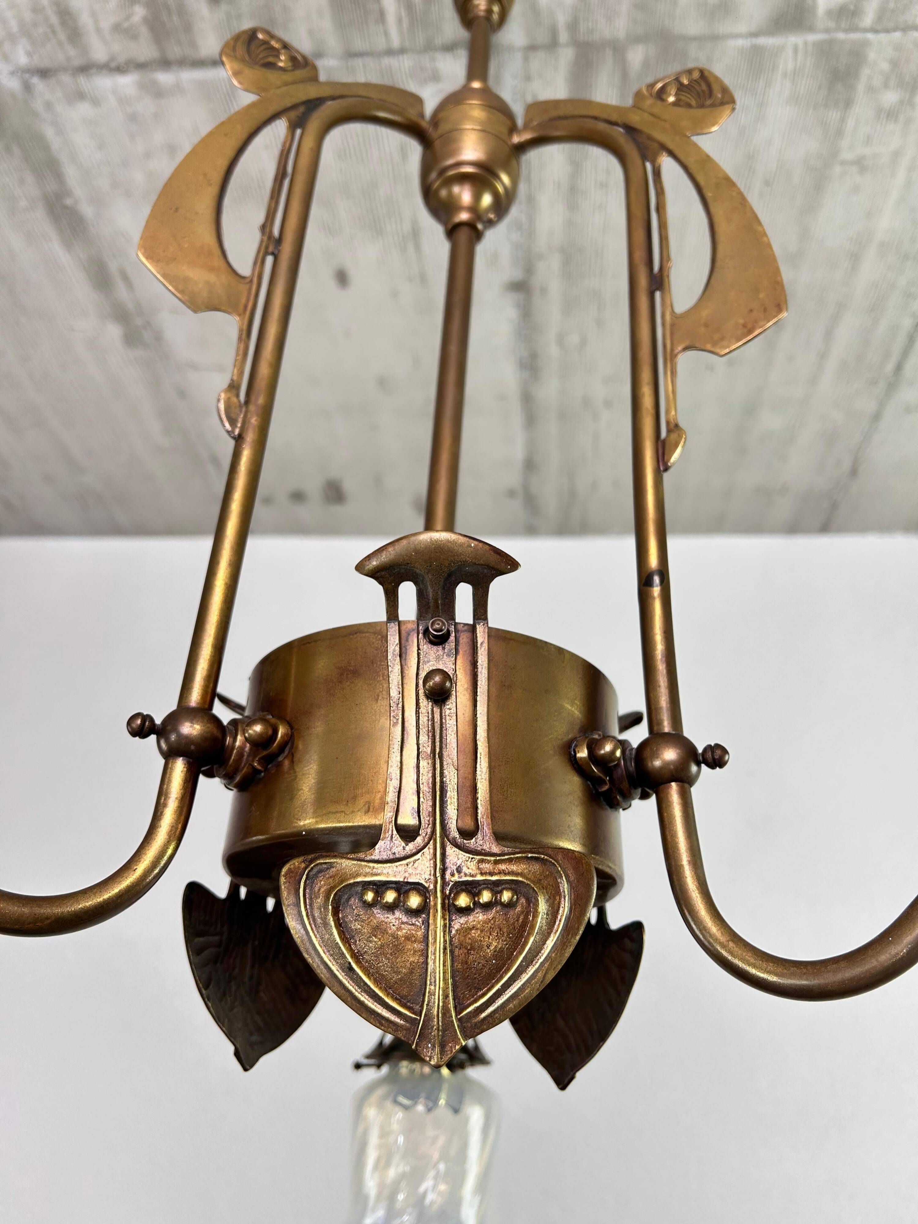 Art Nouveau chandelier with three arms and opalescent iridescent glass.