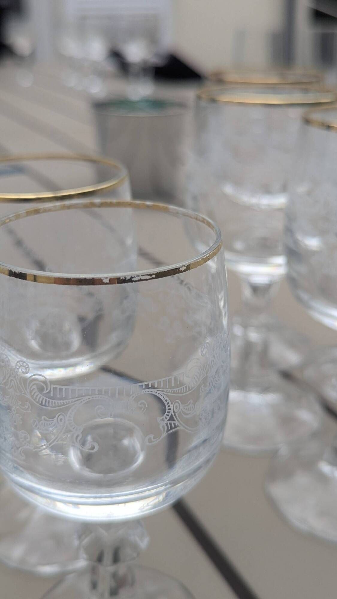 Set of 15 engraved crystal glasses with a gold rim.