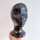 Black ceramic vase with a woman's face.