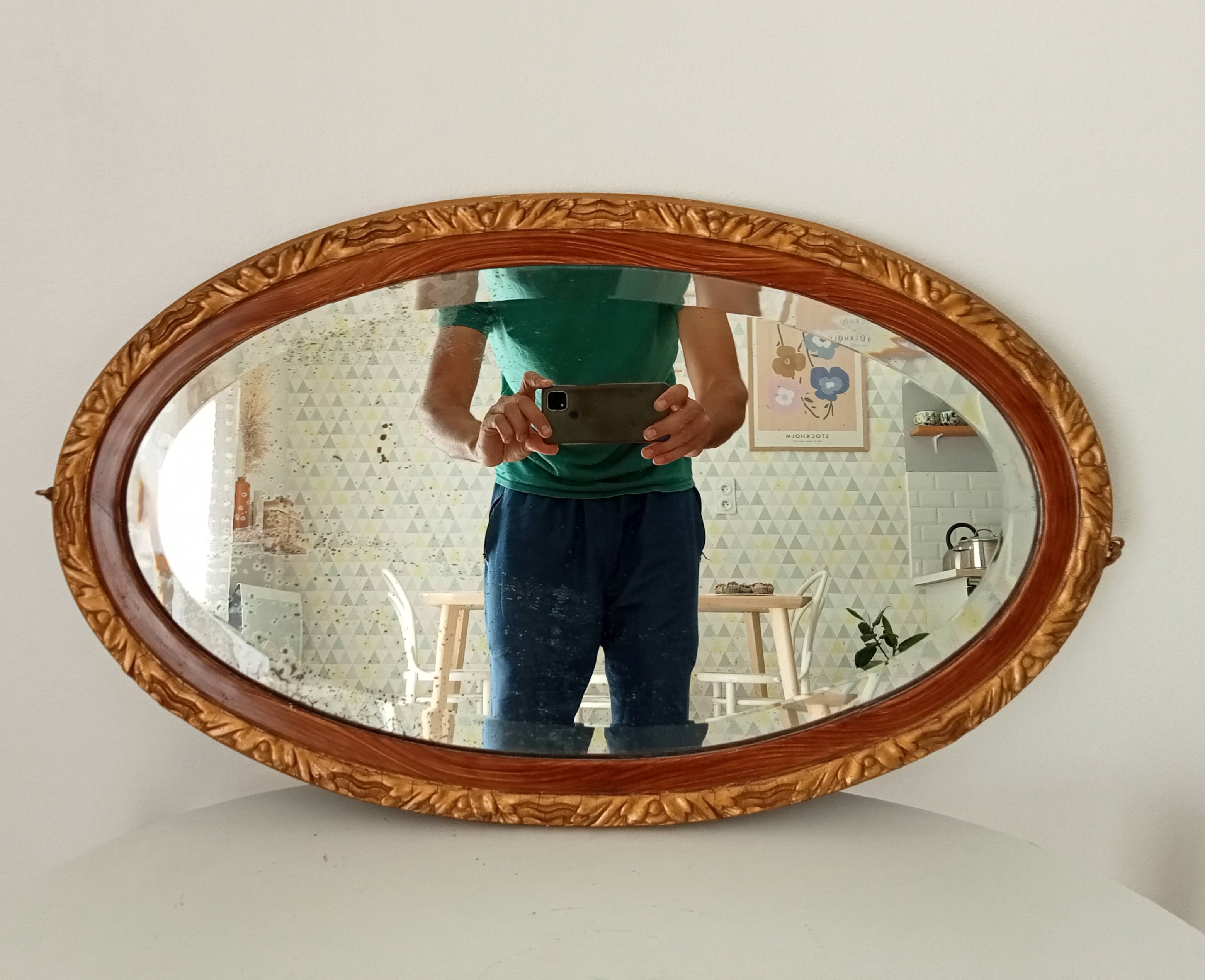 Antique oval mirror with beveled glass in wood and stucco, 19th century