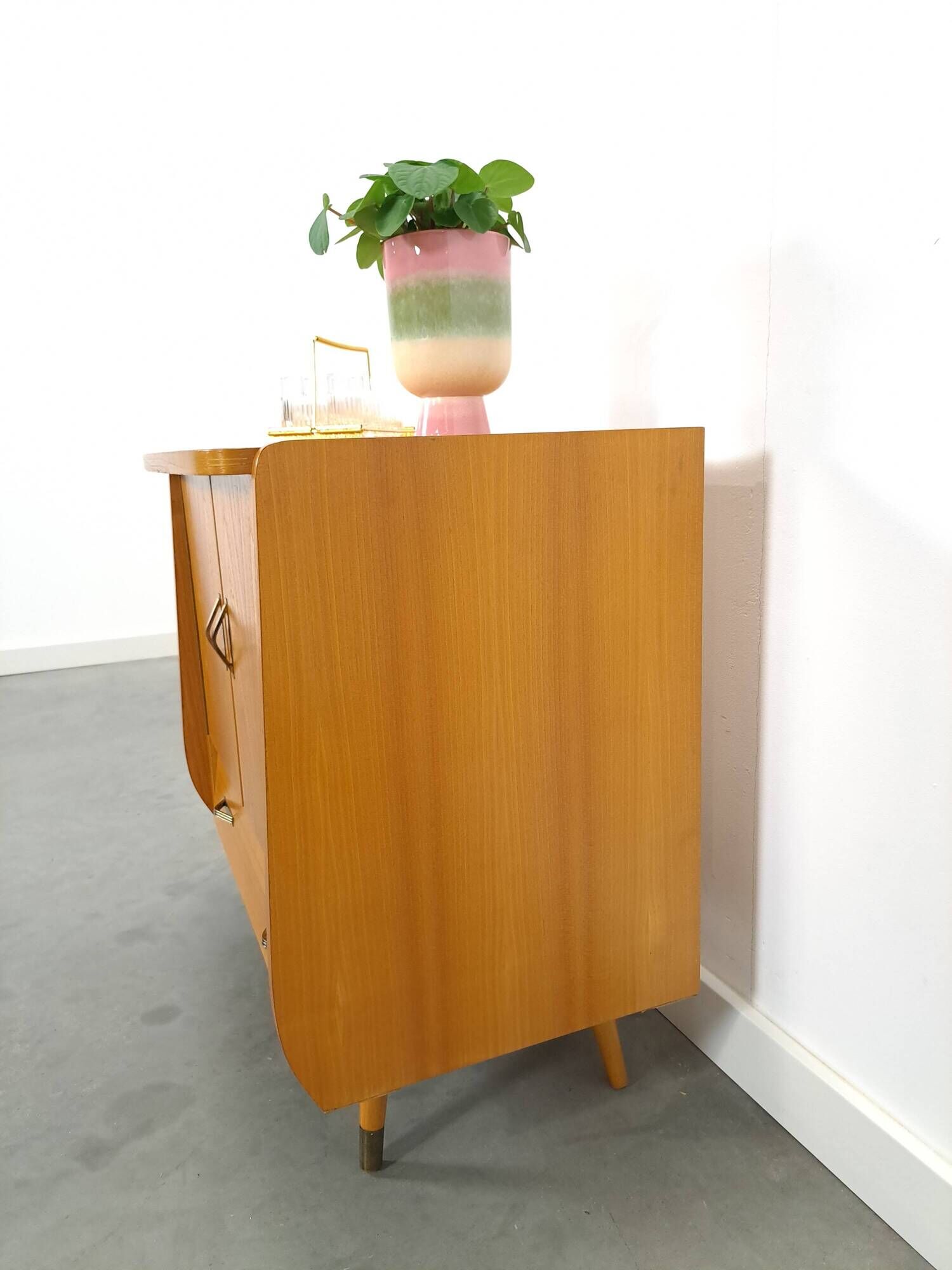 Meuble TV audio avec poignées en laiton et pieds inclinés.
