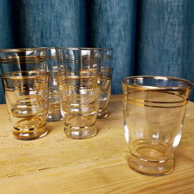 Set of 9 antique glasses with gold rim.
