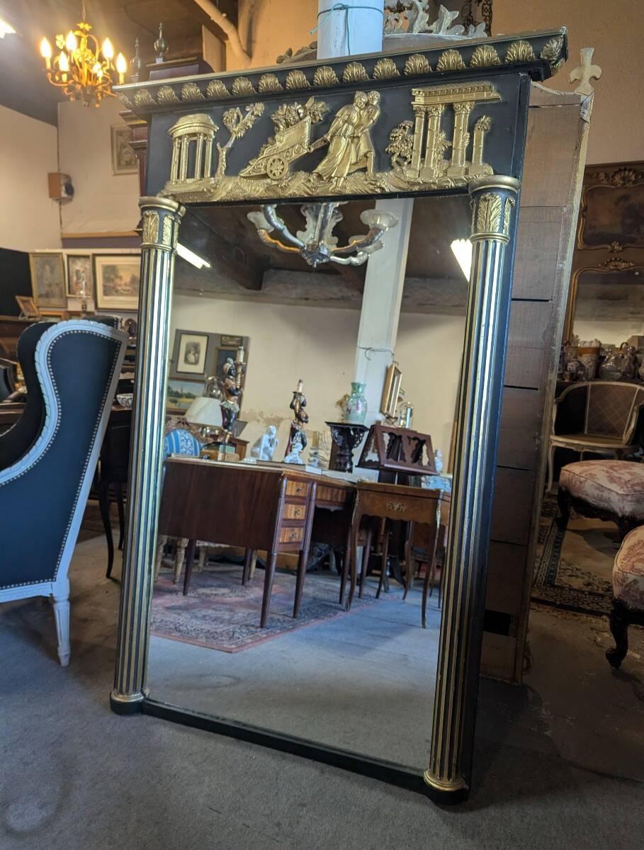 Large Empire-style mirror in dark green painted wood and gilded stucco.