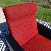 Pair of vintage armchairs in black faux leather and red fabric.