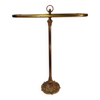 Old golden brass towel rack on baroque style foot