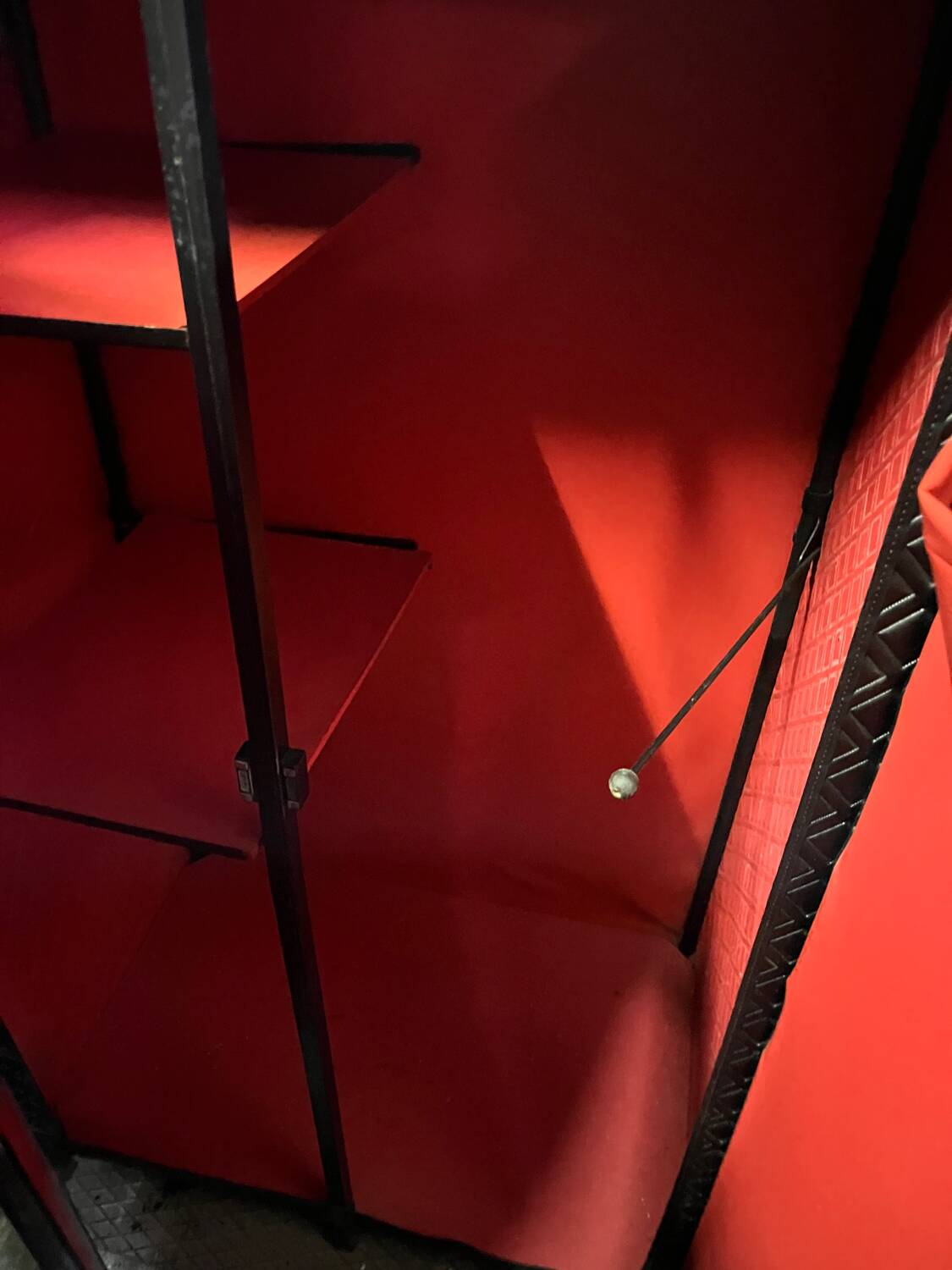 Contemporary wardrobe in black faux leather with diamond pattern and gold handles.