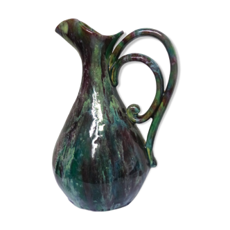 Old vintage ceramic pitcher green color in pink, purple reflections