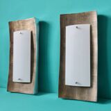 Pair of wall sconces in gold-plated alloy with bas-relief and opaline glass. Germany, 1980