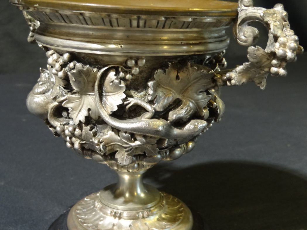 Carved silver bronze vase mounted on marble pedestal