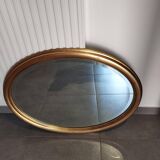 Large and elegant oval gilded mirror with its beveled glass