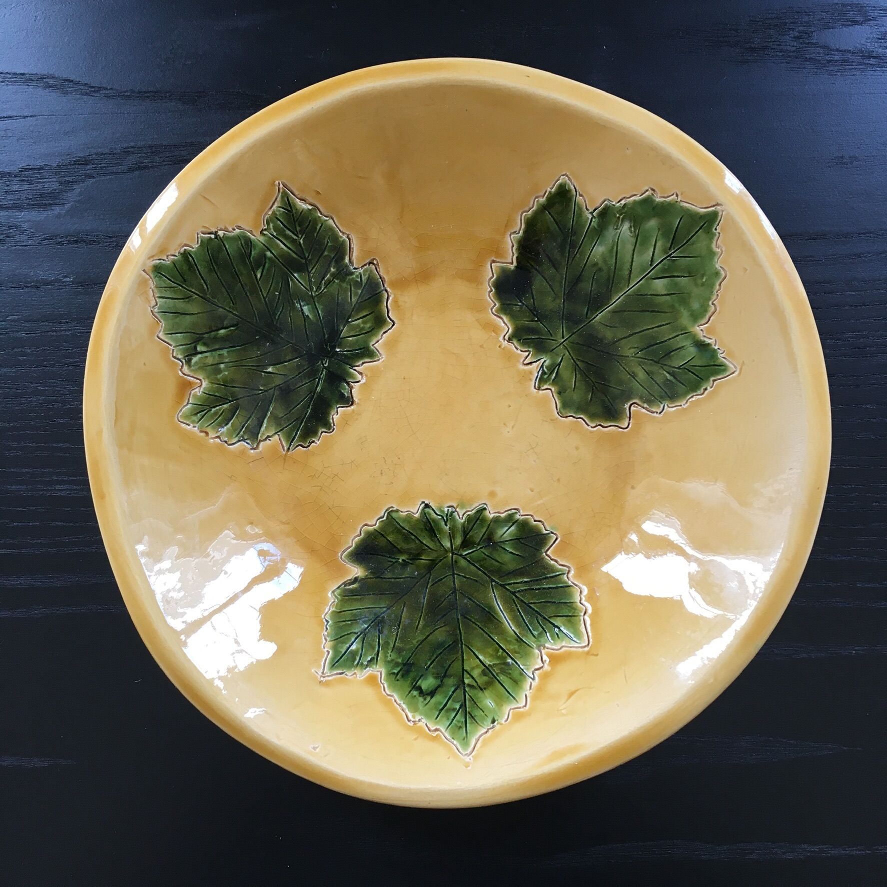 Plate signed with green leaf decoration.