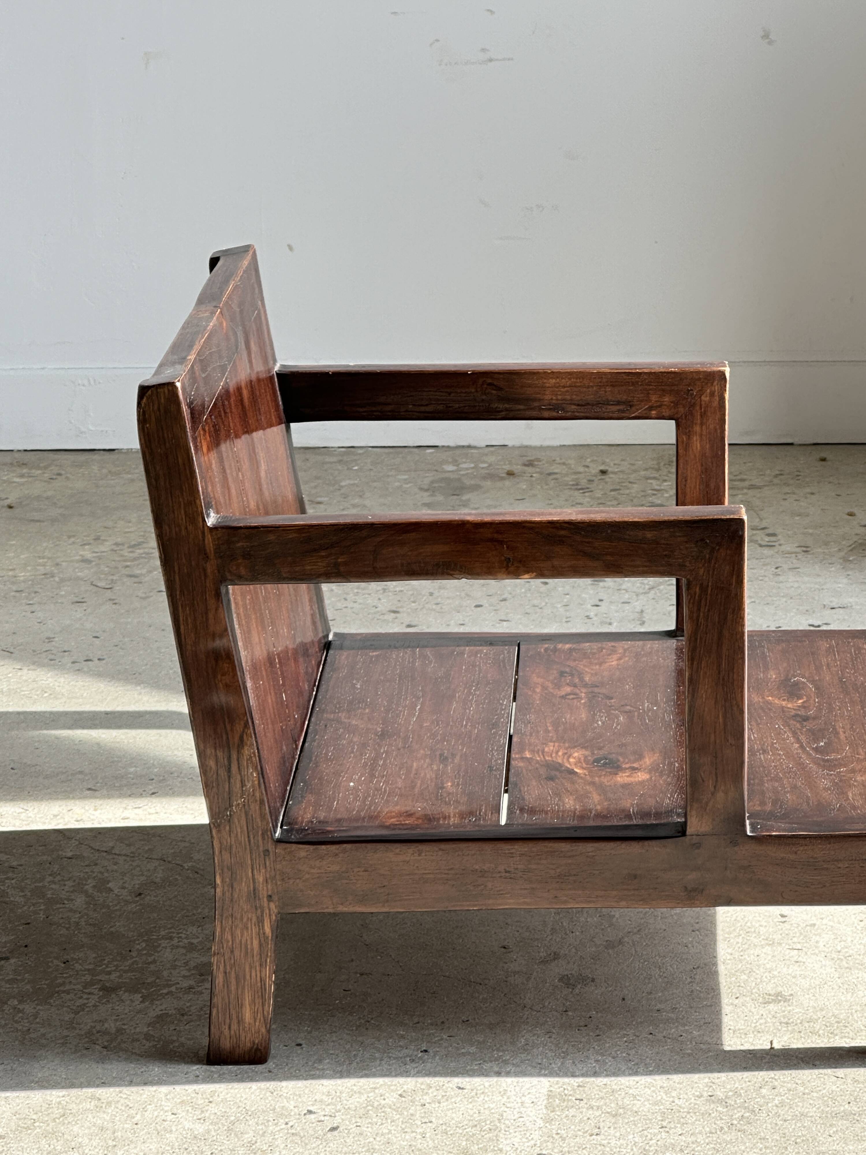 Small low armchair in varnished brown wood