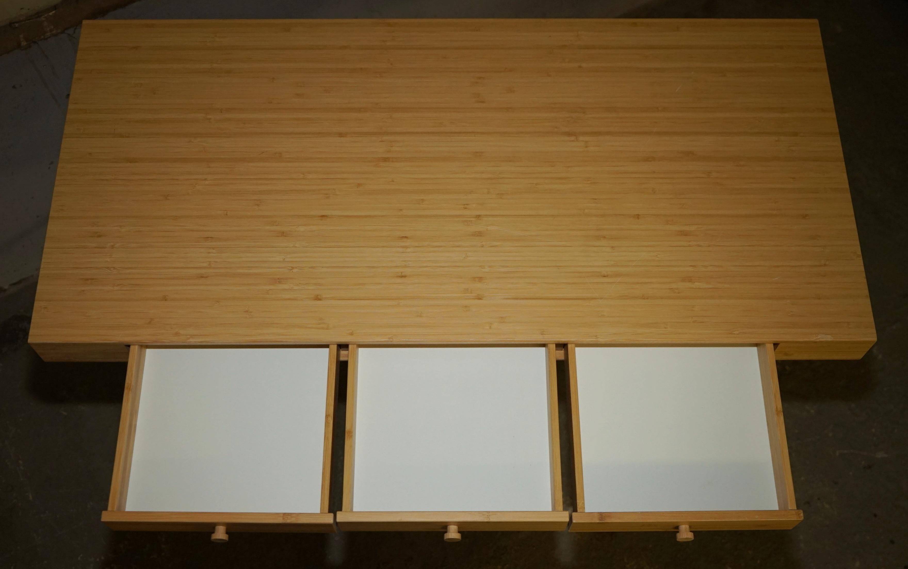 Small bamboo desk with three drawers.