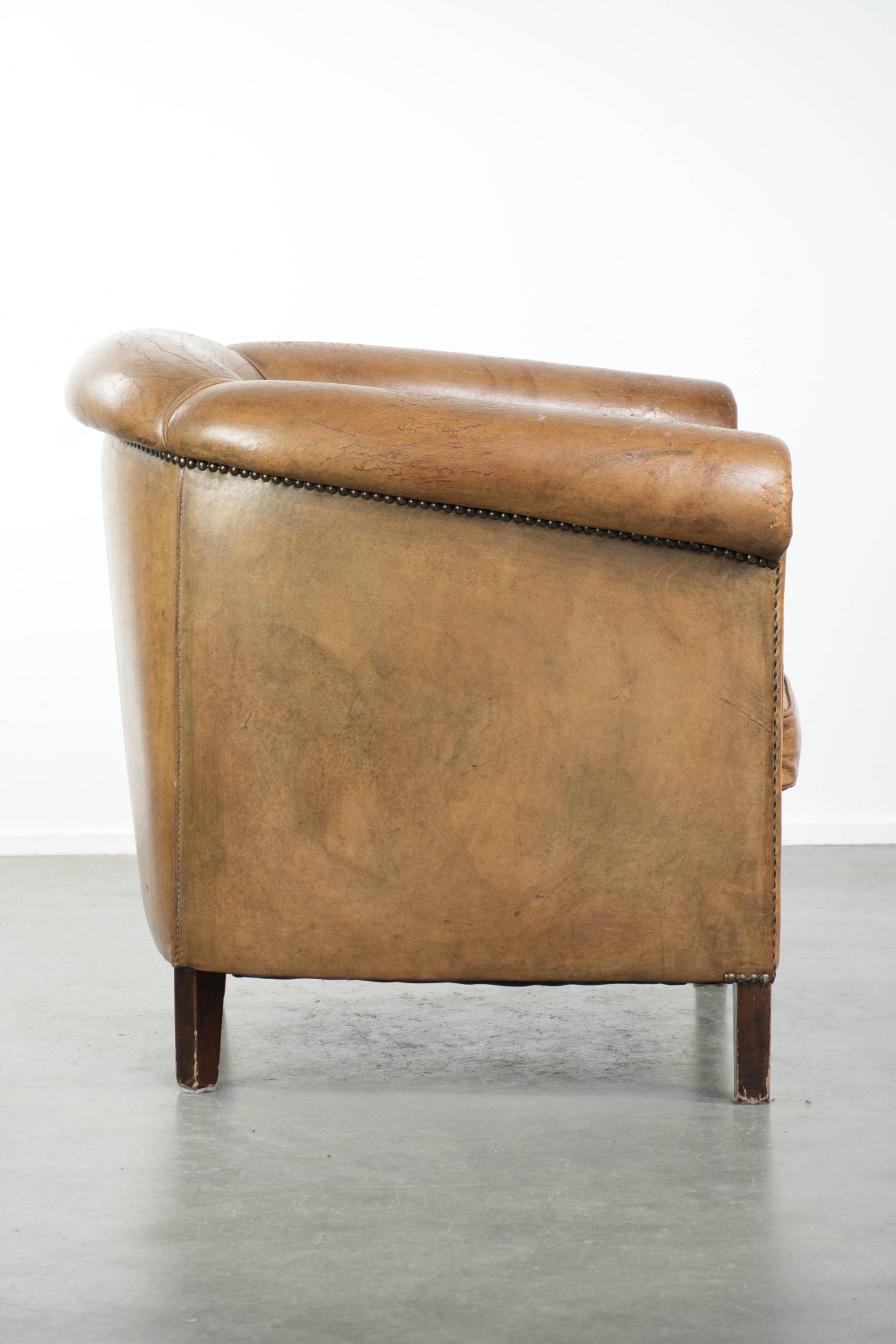 Vintage sheepskin club armchair finished with decorative nails
