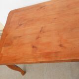 Large solid wood table with integrated extensions.