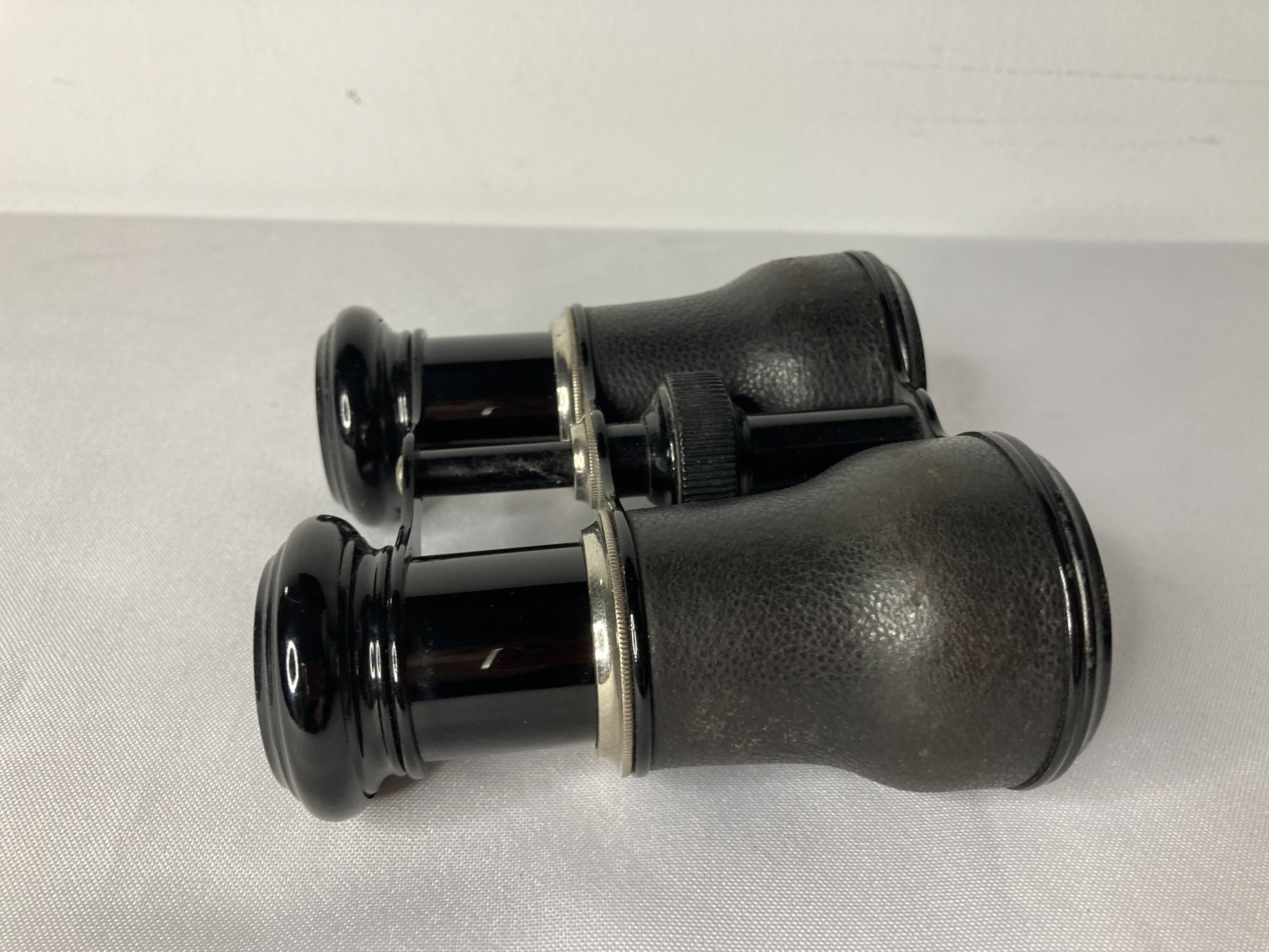 Old pair of binoculars sheathed leather black silver metal