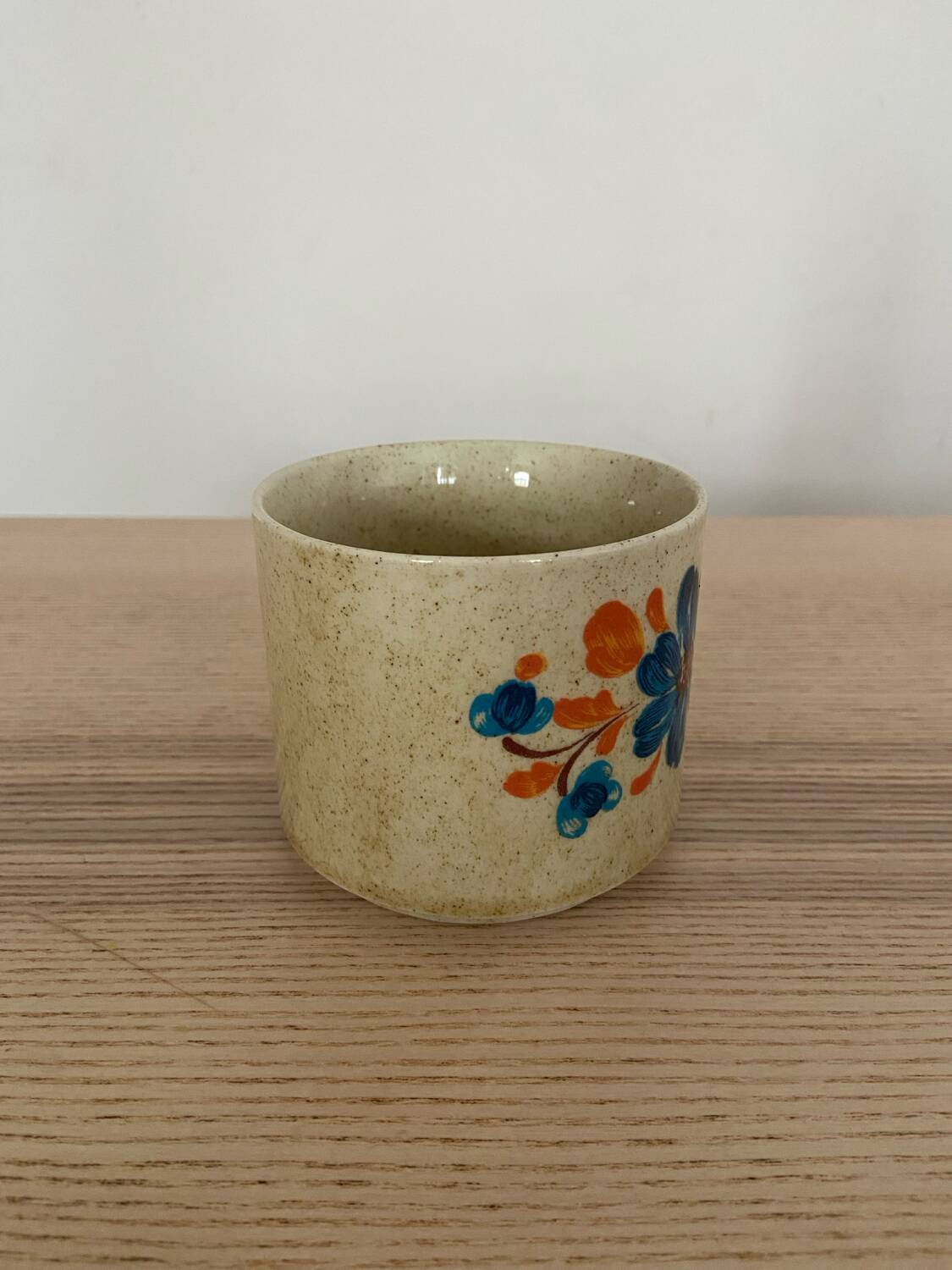 Speckled stoneware cup with blue flower