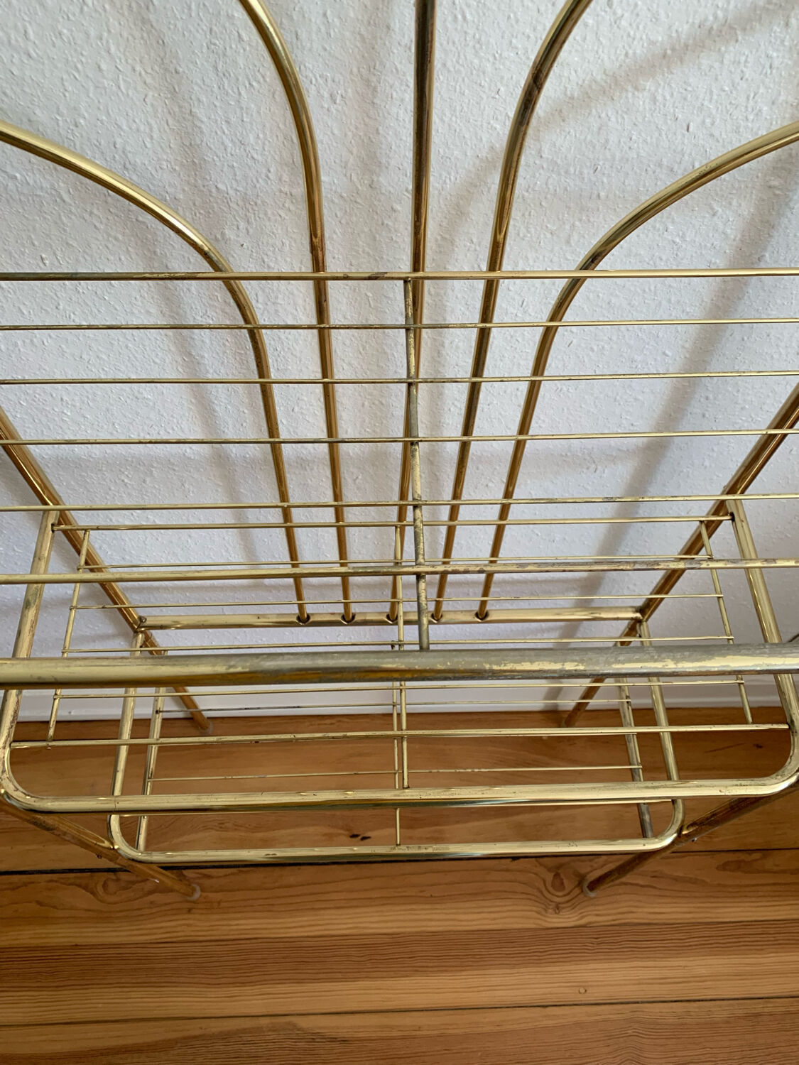 Gilded metal grid shelf in the shape of a vaulted arch