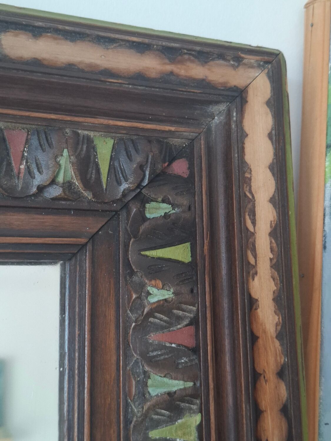 Antique mirror with a carved and painted wooden frame