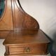 Antique carved wooden dressing table with marble and tilting oval mirror.