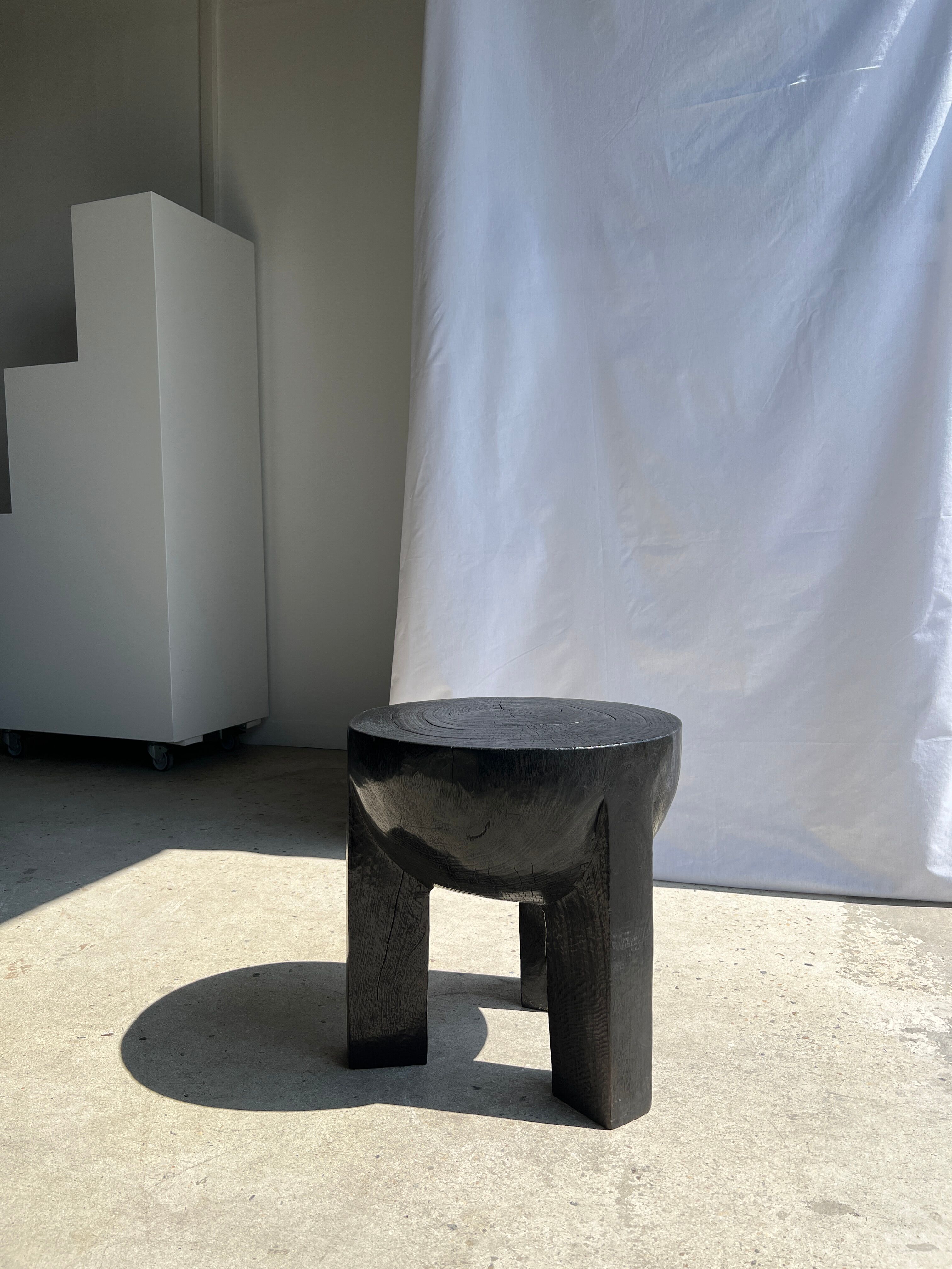 Black mango wood tripod side table with a semi-spherical top, height: 45 cm, diameter: 44 cm.