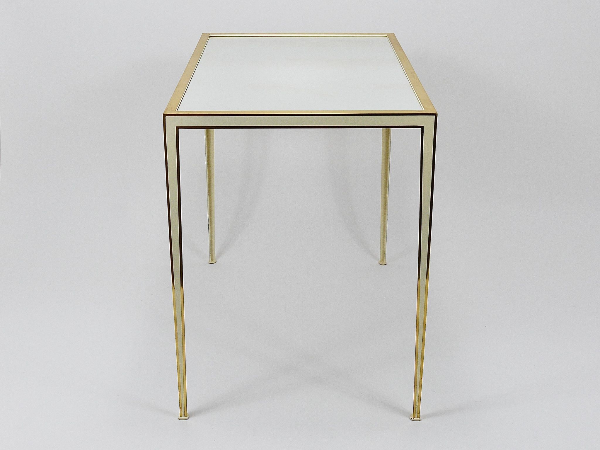 A pair of brass and white mirror tables from Vereinigte Werkstätten, Germany, 1970s.