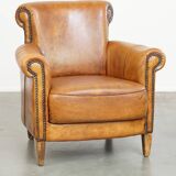 Comfortable, cozy armchair made of sheepskin leather with a proper finish with decorative nailheads