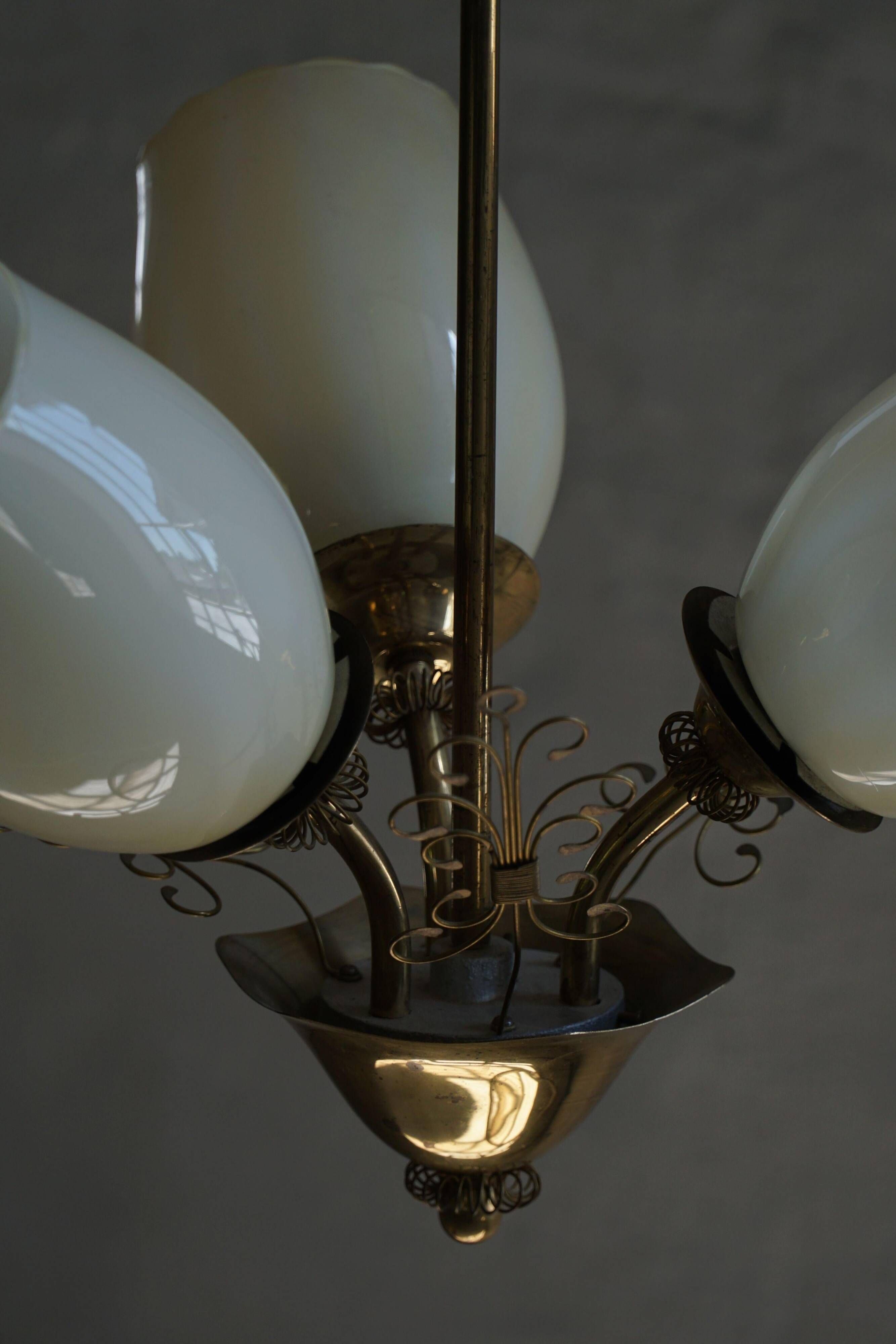 Paavo Tynell for Idman Oy, three-branch chandelier in brass and glass, mid-century, 1940s.